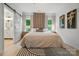 A stylish main bedroom boasts a unique accent wall, light hardwood floors, and a view into the main bath at 1212 Mason Way, Mount Holly, NC 28120