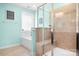 Bright bathroom showcasing a shower with glass doors, a soaking tub, and light-blue colored walls at 13359 Caite Ridge Rd, Davidson, NC 28036