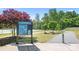 Sign for Plum Creek Park and Plum Creek Greenway sits next to a paved walkway in a wooded area at 13359 Caite Ridge Rd, Davidson, NC 28036