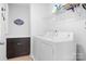 This laundry room has white appliances, dark wood cabinets, and wire shelving at 13359 Caite Ridge Rd, Davidson, NC 28036
