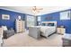 This primary bedroom has a ceiling fan, a large window, gray walls, and a flatscreen tv hidden in a cabinet at 13359 Caite Ridge Rd, Davidson, NC 28036