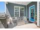 Relaxing covered back patio with ample seating, a grill, and a blue-painted door at 13359 Caite Ridge Rd, Davidson, NC 28036