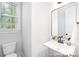 White powder room features a pedestal sink, mirror, and window at 1359 Russell St, Rock Hill, SC 29730