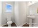 Bathroom featuring a pedestal sink, white toilet, and a window with natural light at 1359 Russell St, Rock Hill, SC 29730