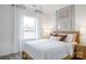 Inviting bedroom featuring a large window and modern decor with a wooden headboard and neutral color scheme at 14015 Penbury Ln # 373, Charlotte, NC 28278
