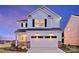 Attractive two-story home showcasing a large garage, manicured landscaping, and a welcoming facade with modern lighting at 14015 Penbury Ln # 373, Charlotte, NC 28278
