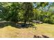 Lush backyard with mature trees, a charming rock garden, and a rustic chicken coop, perfect for outdoor enjoyment at 145 Mccreek Dr, China Grove, NC 28023