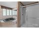 Bathroom showcasing a large jetted tub with a shower behind a glass door at 145 Mccreek Dr, China Grove, NC 28023