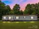 Evening view of the house featuring a well-manicured lawn and inviting entrance at 145 Mccreek Dr, China Grove, NC 28023