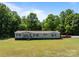 Charming single-story home on a lush green lawn with mature trees in the background at 145 Mccreek Dr, China Grove, NC 28023