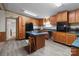 Fully equipped kitchen with wood cabinets, black appliances, island with seating, and modern flooring at 145 Mccreek Dr, China Grove, NC 28023