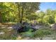 Backyard pond surrounded by rocks and lush vegetation, creating a serene outdoor retreat at 145 Mccreek Dr, China Grove, NC 28023