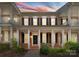 Charming two-story brick home with a welcoming front porch and beautiful landscaping at sunset at 155 Harper Lee St, Davidson, NC 28036