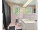 Retro bathroom with pink tile, floral wallpaper, and plenty of natural light from the window at 1574 Jarrett Farm Rd, Newton, NC 28658