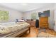 Comfortable bedroom with hardwood floors, two windows, and classic wooden furniture for ample storage at 1574 Jarrett Farm Rd, Newton, NC 28658