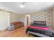 Spacious bedroom with hardwood floors, patterned wallpaper, and a comfortable seating area at 1574 Jarrett Farm Rd, Newton, NC 28658