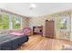 Sunlit bedroom with vintage wallpaper, hardwood floors, and large windows overlooking the yard at 1574 Jarrett Farm Rd, Newton, NC 28658