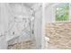 Modern bathroom with a walk-in shower, stone pebble flooring, glass enclosure, and convenient built-in shelves at 1574 Jarrett Farm Rd, Newton, NC 28658