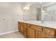 Bright bathroom featuring a dual sink vanity with wooden cabinets and a large mirror at 16291 Raven Crest Dr, Indian Land, SC 29707