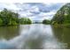 Picturesque lake view surrounded by lush greenery and trees, showcasing the community's natural beauty at 16291 Raven Crest Dr, Indian Land, SC 29707