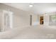 Spacious living room has plush carpeting, neutral paint, and multiple entryways for seamless flow at 16291 Raven Crest Dr, Indian Land, SC 29707