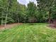 An open backyard features mature trees and landscaping for an abundance of privacy at 16319 Ashlyn Chase Ct, Charlotte, NC 28277