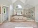Primary bathroom featuring tiled floor, whirlpool tub, large windows, and glass enclosed shower at 16319 Ashlyn Chase Ct, Charlotte, NC 28277