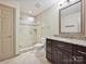 This bathroom features tile flooring, a glass-enclosed shower, and a granite countertop at 16319 Ashlyn Chase Ct, Charlotte, NC 28277