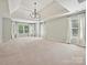 Spacious main bedroom with tray ceiling, chandelier, and lots of natural light from the many windows at 16319 Ashlyn Chase Ct, Charlotte, NC 28277