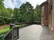 Back deck with stairs featuring a brick home exterior and wooded view at 16319 Ashlyn Chase Ct, Charlotte, NC 28277