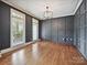 Stylish dining room with dark gray paneled walls, hardwood floors, and elegant chandelier at 16319 Ashlyn Chase Ct, Charlotte, NC 28277