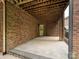A covered patio with exposed rafters showing the brick walls and concrete flooring at 16319 Ashlyn Chase Ct, Charlotte, NC 28277