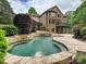Backyard showcases a custom pool with waterfall feature with mature landscaping and deck at 16319 Ashlyn Chase Ct, Charlotte, NC 28277