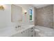 Elegant bathroom with a soaking tub, luxurious vanity, and stylish lighting fixtures at 1719 Shoreham Dr, Charlotte, NC 28211