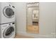 Convenient laundry room with stacked washer and dryer, along with a decorative mirror at 1719 Shoreham Dr, Charlotte, NC 28211