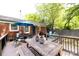 Multi-tiered back deck with dining and relaxing spaces, with a view of the lush backyard and mature trees at 1816 Anderson St, Charlotte, NC 28205