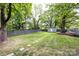 Expansive backyard featuring a shed, gray horizontal fence and stepping stones surrounded by mature trees offering lots of privacy at 1816 Anderson St, Charlotte, NC 28205