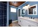 Bathroom boasting double sinks, white cabinetry, wood ceiling, and blue walls, offering functionality and charm at 1816 Anderson St, Charlotte, NC 28205