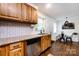 Well-organized kitchen area that connects to the dining space, showcasing wooden cabinets and tile backsplash at 1816 Anderson St, Charlotte, NC 28205