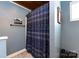 Stylish shower area features modern blue shower curtain, white tile, and neutral flooring, creating a clean space at 1816 Anderson St, Charlotte, NC 28205