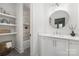 Stylish bathroom with floating shelves, tiled shower/tub, round mirror, and white vanity at 1816 Parson St, Charlotte, NC 28205