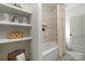 Modern bathroom features floating shelves, tiled shower with niche, and neutral color palette at 1816 Parson St, Charlotte, NC 28205