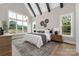 Comfortable primary bedroom with large windows, wood flooring, and decorative accents at 1816 Parson St, Charlotte, NC 28205