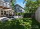 Landscaped backyard with patio, outdoor seating, and a lush lawn at 1900 Nassau Blvd, Charlotte, NC 28205