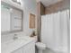 Modern bathroom with a white vanity, speckled countertop, and neutral shower with curtain at 1900 Nassau Blvd, Charlotte, NC 28205
