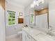 Bathroom featuring a double sink vanity with shower/tub combo and a window for natural light at 1900 Nassau Blvd, Charlotte, NC 28205
