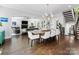 Open-concept dining room showcases hardwood floors, modern light fixture, and views of the living room at 1900 Nassau Blvd, Charlotte, NC 28205