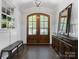 Elegant front foyer showcasing hardwood floors, arched doorways, and a decorative mirror, creating a warm ambiance at 1900 Nassau Blvd, Charlotte, NC 28205