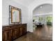 Bright and open front foyer with dark wood flooring, decorative mirror, and arched doorway at 1900 Nassau Blvd, Charlotte, NC 28205