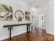 Elegant hallway with hardwood floors, a console table, decorative art, and access to living areas at 1900 Nassau Blvd, Charlotte, NC 28205